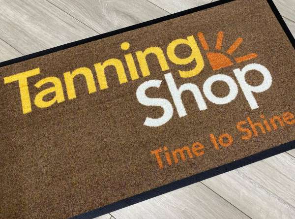 A printed Carpet Mat with the Tanning Shop Logo